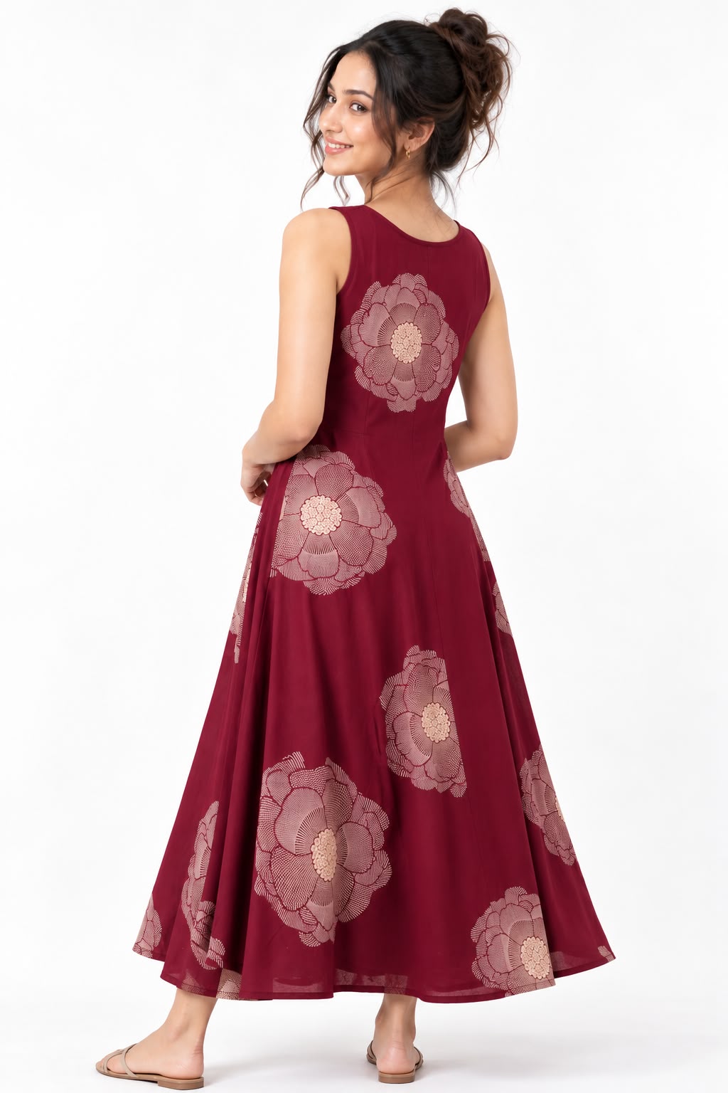 Woman wearing a burgundy sleeveless maxi dress with large beige floral prints, styled with nude sandals.