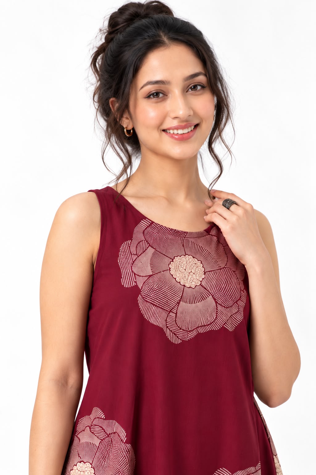 Woman wearing a burgundy sleeveless maxi dress with large beige floral prints, styled with nude sandals.