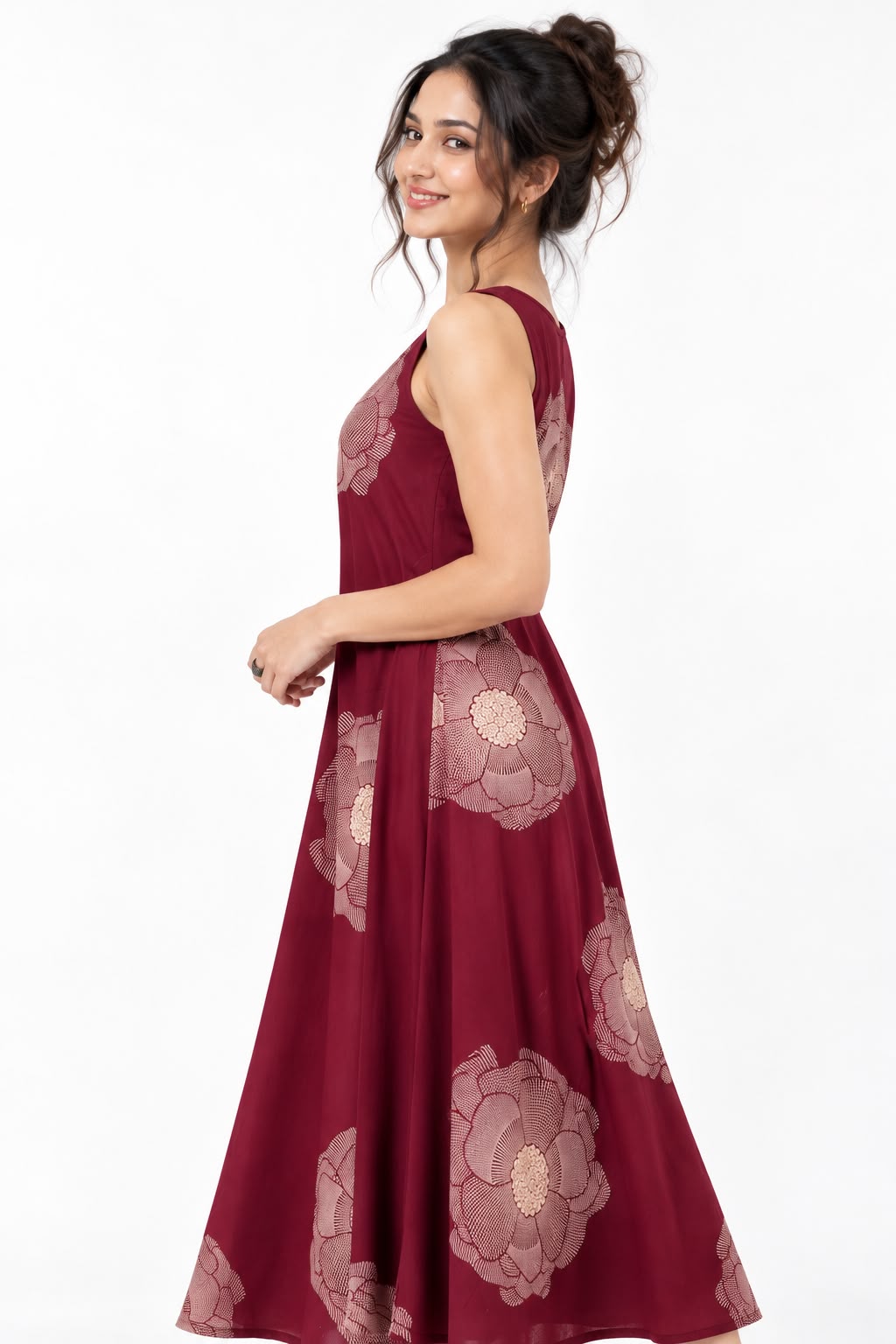 Woman wearing a burgundy sleeveless maxi dress with large beige floral prints, styled with nude sandals.