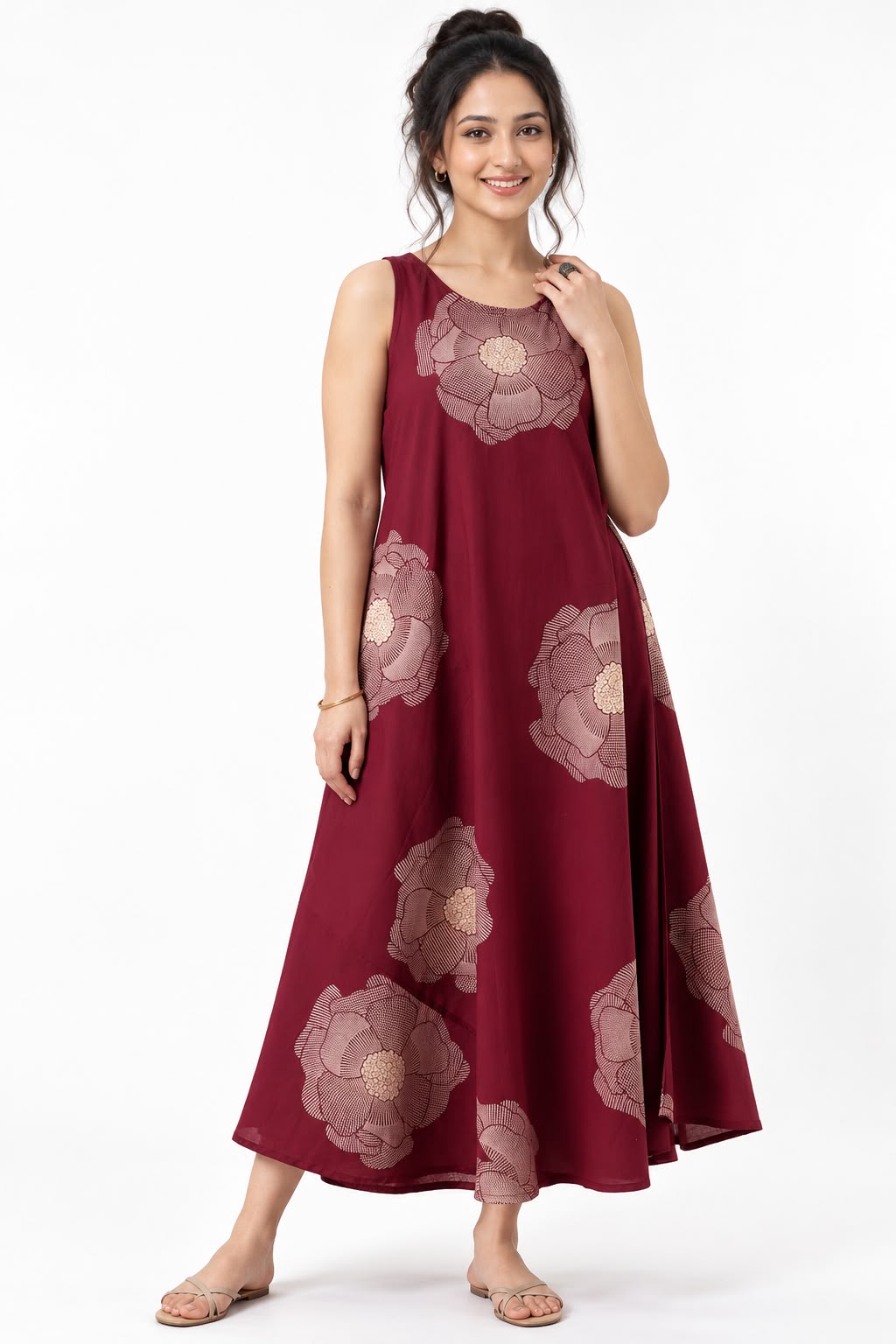 Woman wearing a burgundy sleeveless maxi dress with large beige floral prints, styled with nude sandals.