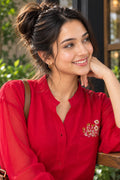 Woman wearing an embroidered women's shirt with sheer puff sleeves and a button-down front