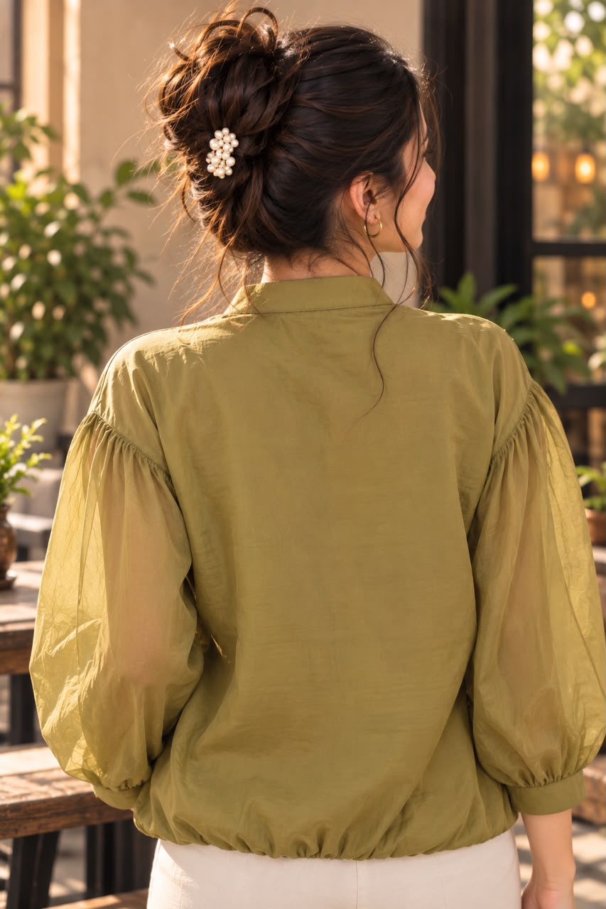 Woman wearing an embroidered women's shirt with sheer puff sleeves and a button-down front